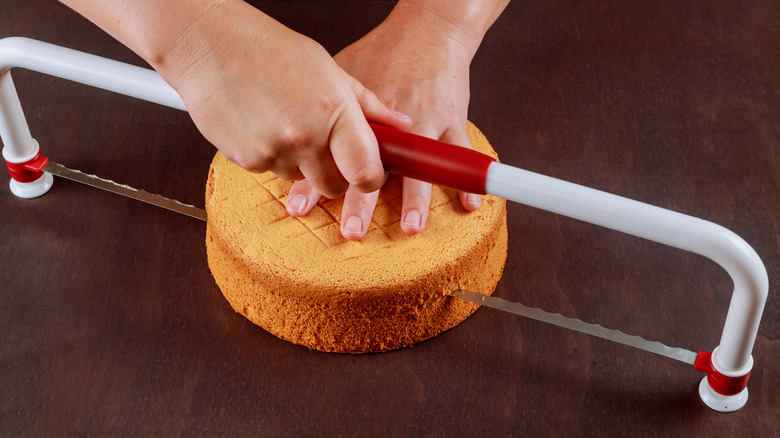 hands cutting cake with leveler
