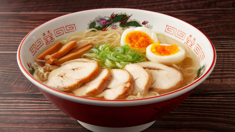 Bowl of asian-style chicken and noodle soup with egg