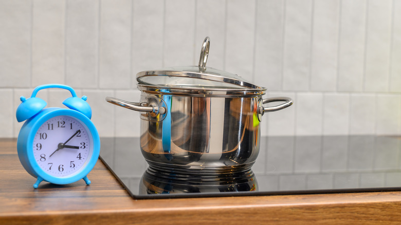 Clock next to cooking pot on stove