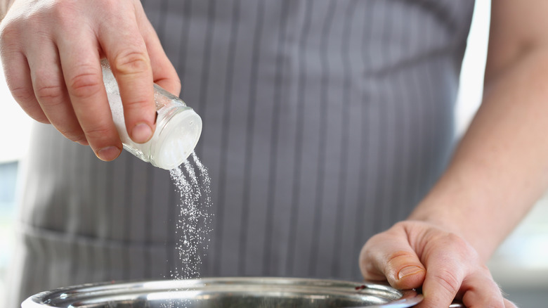 Man pouring salt into pot