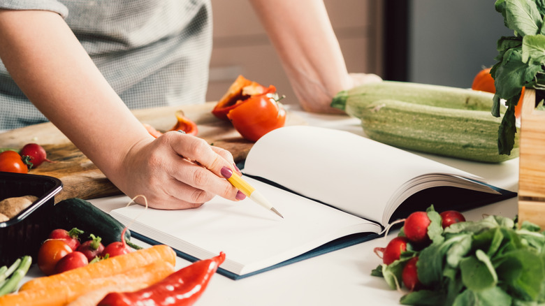 person writing in recipe book