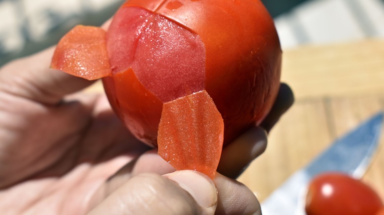 Person peeling a tomato