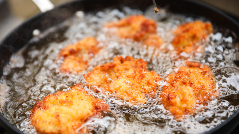 fried chicken pieces floating in oil