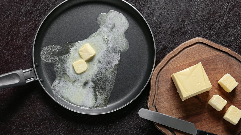 slices of butter melting in a frying pan