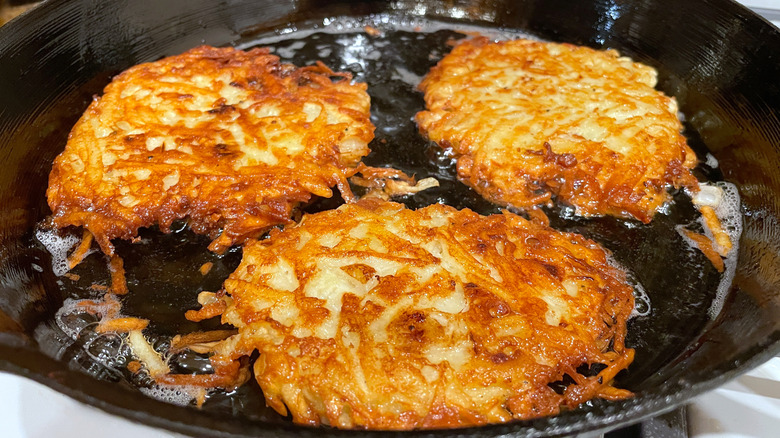 hash browns cooking in a frying pan