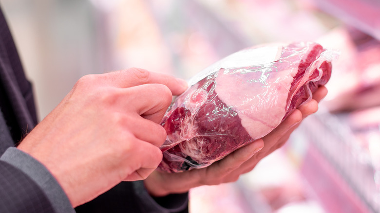 person reading label on package of meat