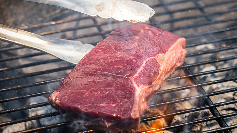 raw steak on a grill