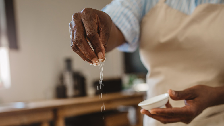 Cook sprinkling salt onto food