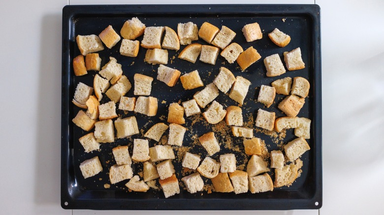 Dry bread cubes on baking sheet