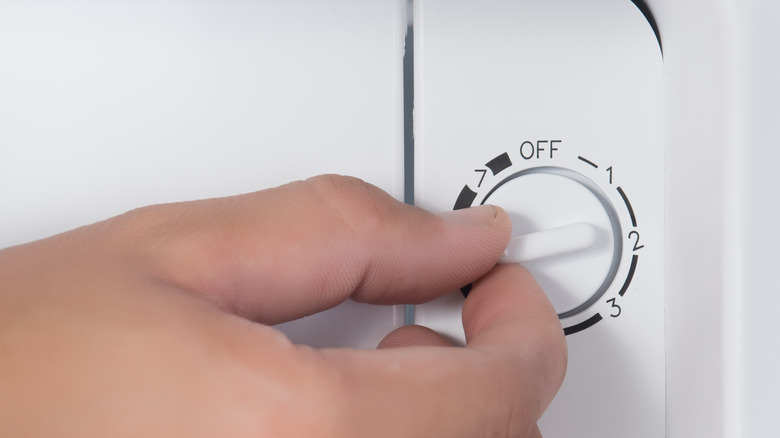 hand adjusting fridge temperature