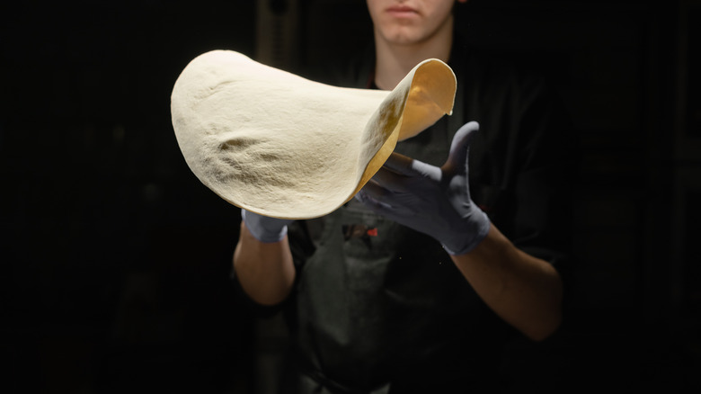 chef tossing pizza dough in air