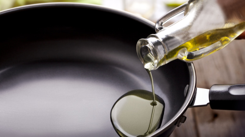 Cooking oil being poured into non-stick pan