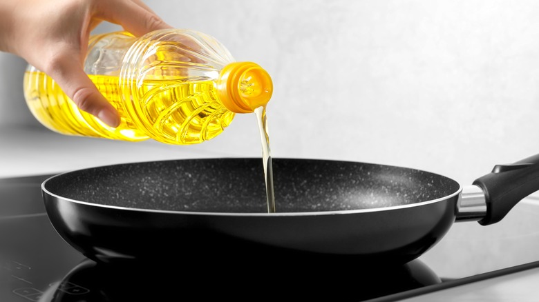 pouring olive oil in skillet