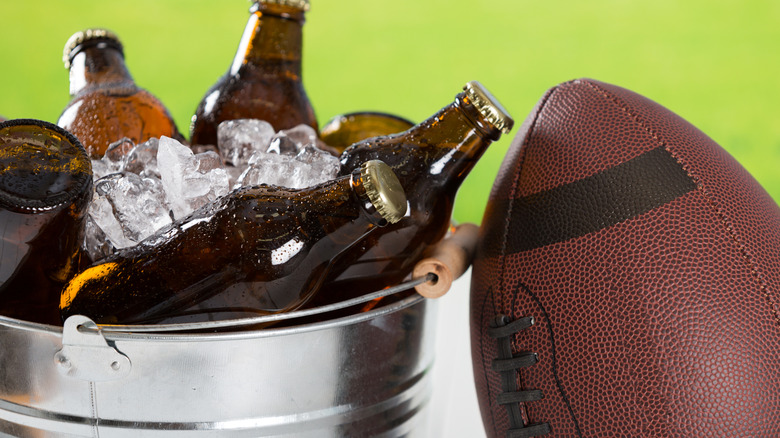 football leaning on bucket of beer