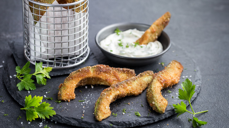 crispy avocado fries with garlic yogurt sause. Dark background