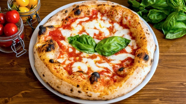 Neapolitan pizza topped with basil leaves 