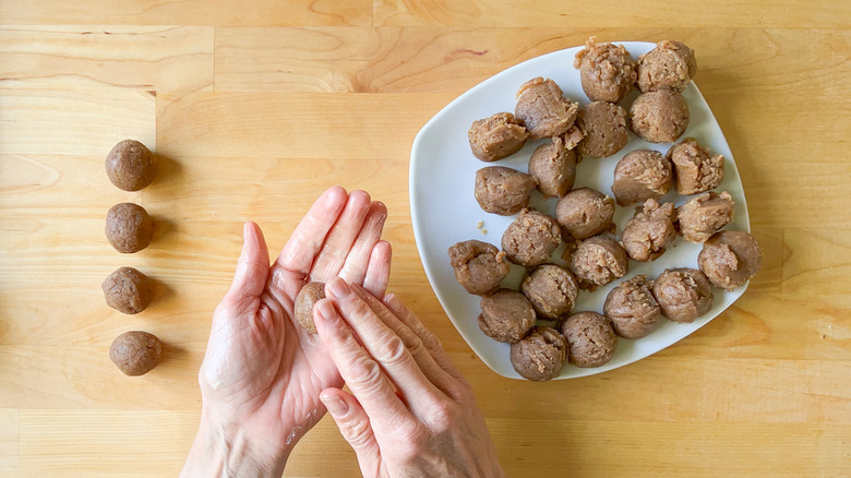 Rolling no-bake snickerdoodle cookie dough balls with hands