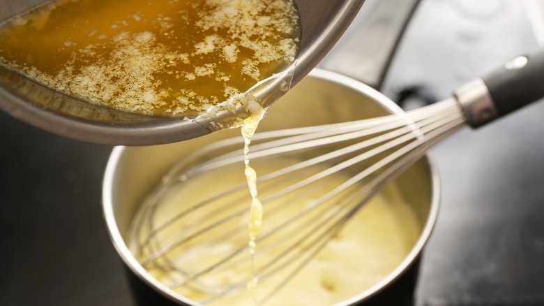 Whisking butter into hollandaise sauce