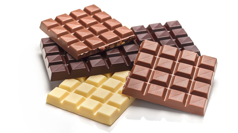 A stack of different types of chocolate bars: milk, dark, and white.