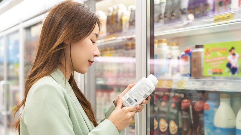 Woman reading expiration date on milk