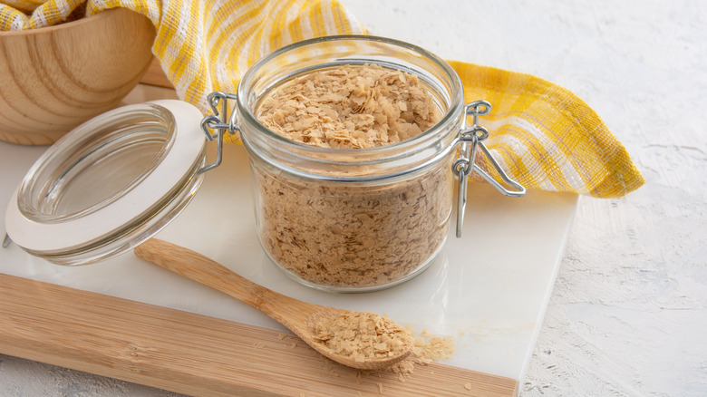 Nutritional yeast flakes in a glass mason jar container with locking clamp lid