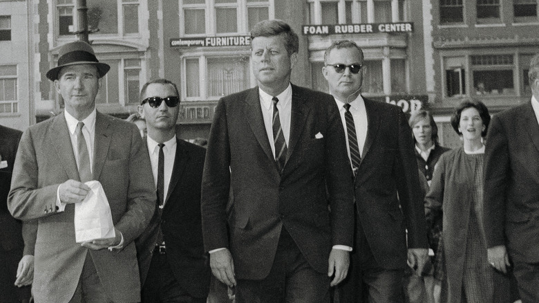 John F. Kennedy walking through streets of Boston with entourage