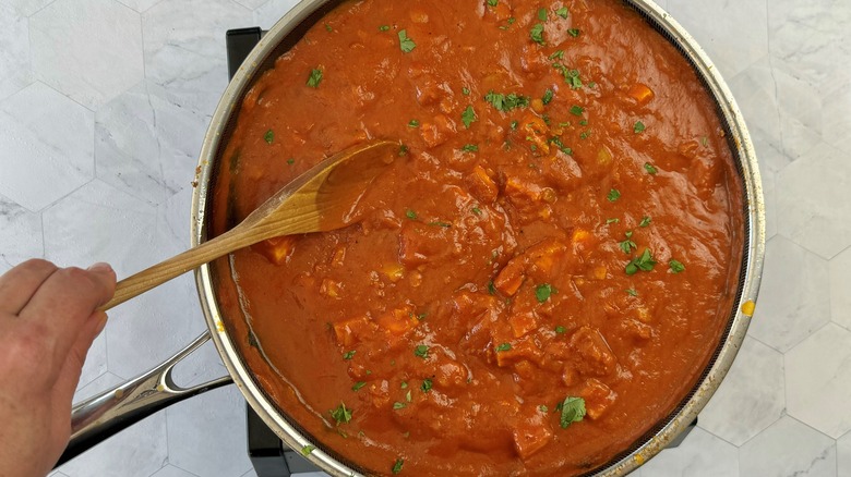 hand stirring tomato sauce