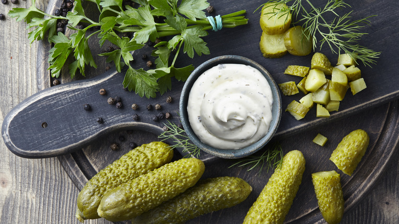 Tartar sauce in bowl with pickles and fresh herbs