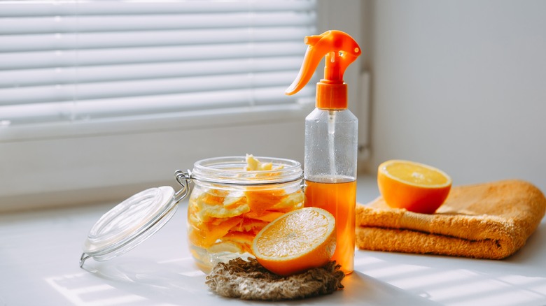 A spray bottle with oranges and a jar of orange peels