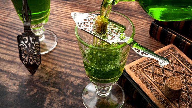 glass of absinthe with medieval looking tablescape