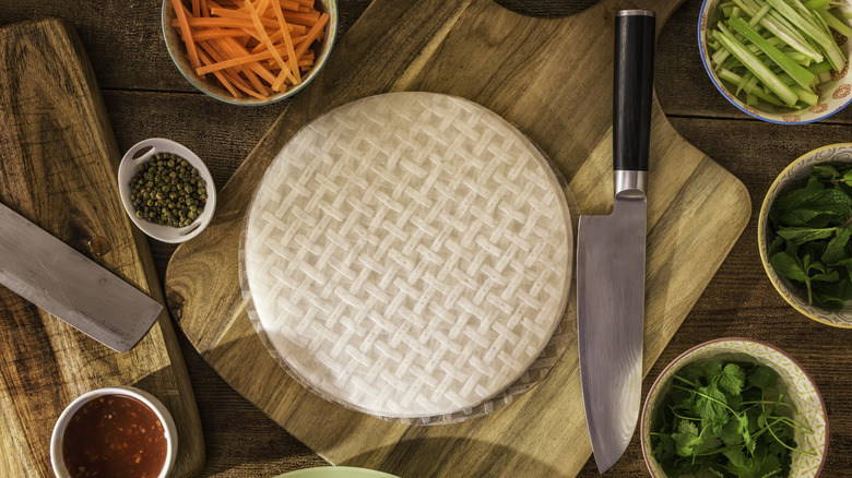 Rice paper surrounded by chopped veggies