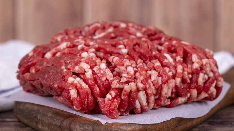 A portion of raw ground beef sits on brown parchment paper