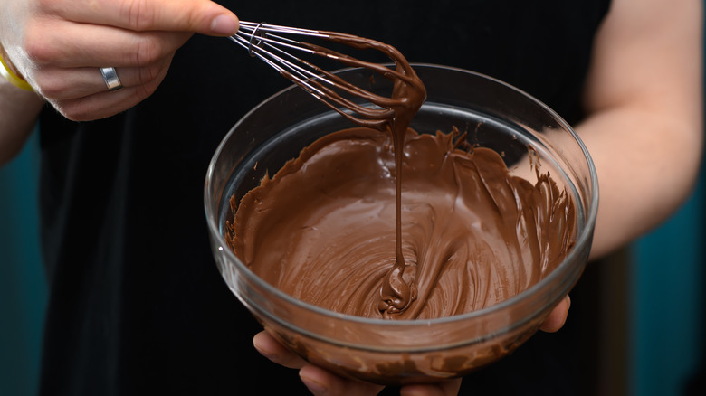 Whisking a bowl of melted chocolate.