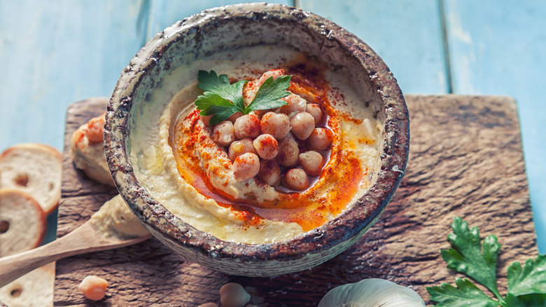 Rustic bowl filled with hummus and whole chickpeas