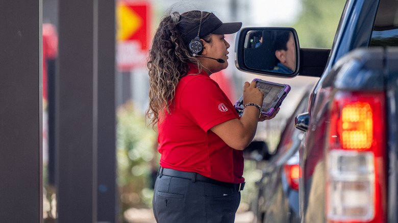 Drive-thru employee taking orders on iPad