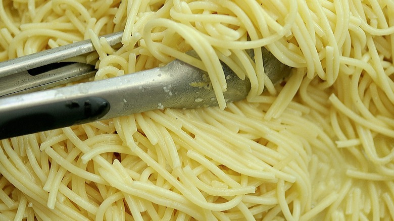 spaghetti noodles in tongs