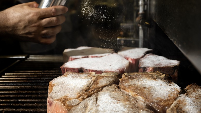 Sprinkling salt on cooking steaks 