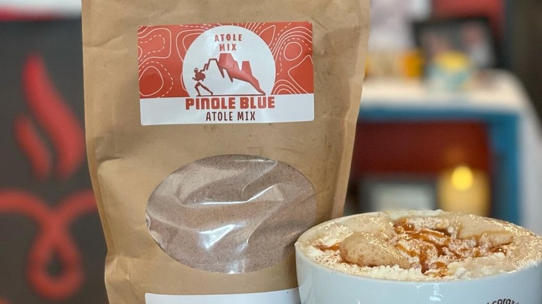 Pinole Blue's drink mix next to a cup of coffee