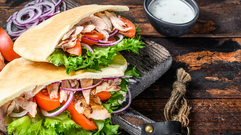 pitas stuffed with salad and chicken on cutting board