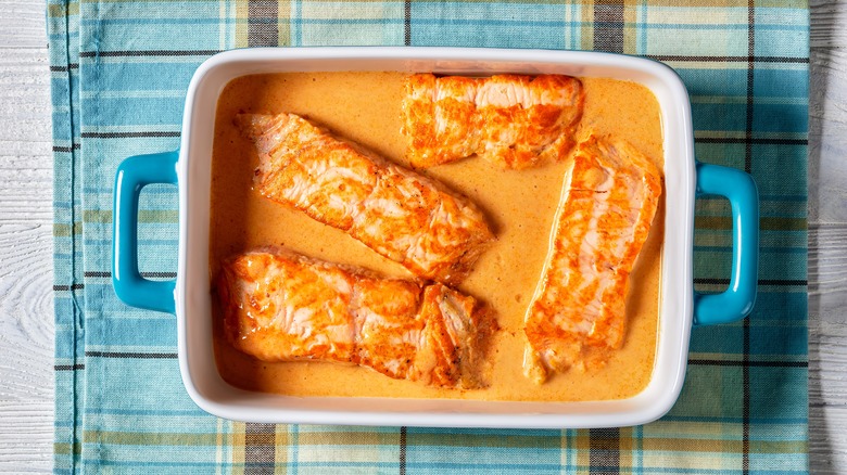 Salmon in curried coconut milk in baking dish