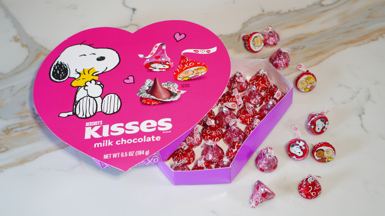 An open heart-shaped box of Snoopy & Friends Hershey's Kisses