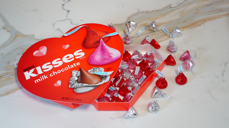 An open heart-shaped box of Hershey's Kisses