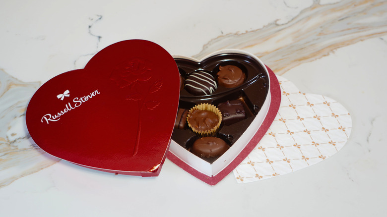 An open heart-shaped box of Russell Stover chocolates