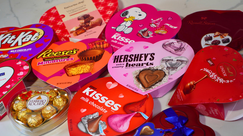 Close-up of eleven closed heart-shaped boxes of chocolate arranged on a marble counter