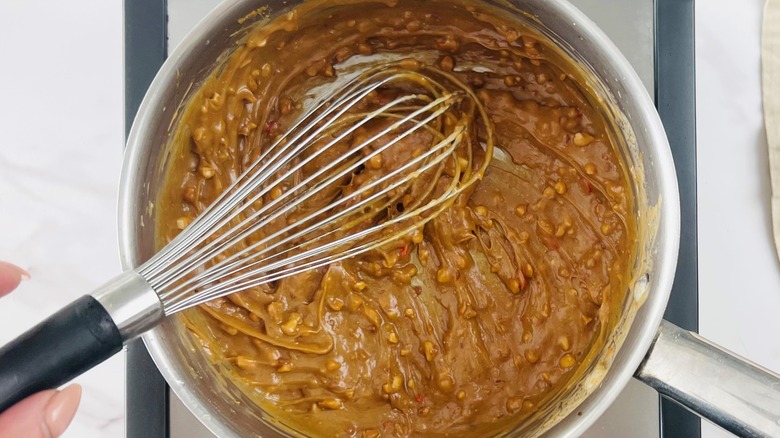 whisking peanut sauce in pan