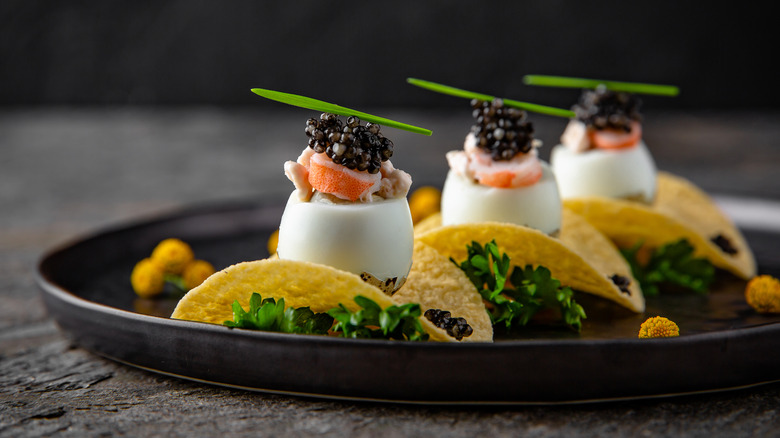 Caviar, lobster, quail egg, and potato chips