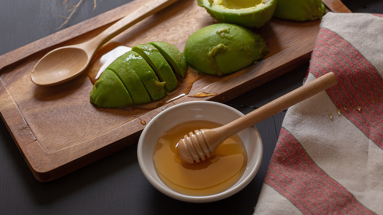Bowl of honey and sliced avocados