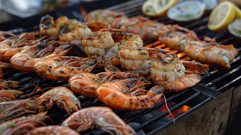 Shrimp on grill with lemon wedges and oysters