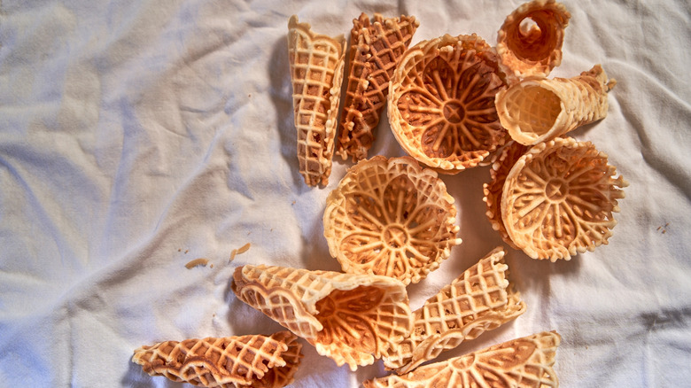 Golden brown pizzelle cookies shaped into cones and bowls