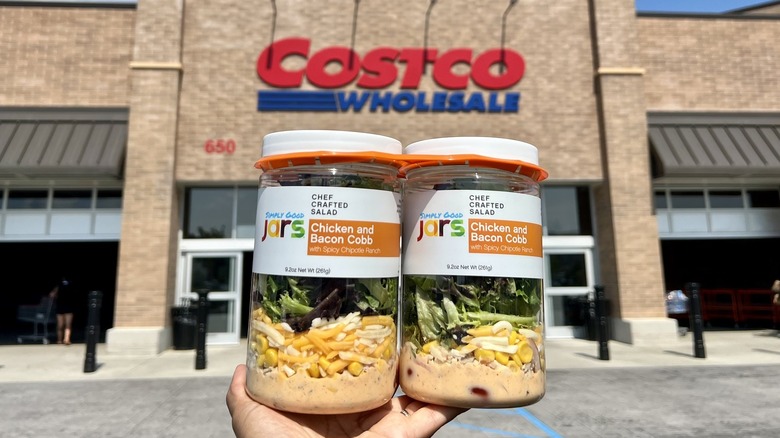 Hand holding Simply Good Jars outside Costco